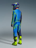 Motocross rider from a rear view wearing 2026 Alpinestars Fluid Apex Pants in Blue and Yellow Fluo, matching blue and yellow jersey and helmet, and bright neon yellow boots, coordinated racing gear for off-road performance.