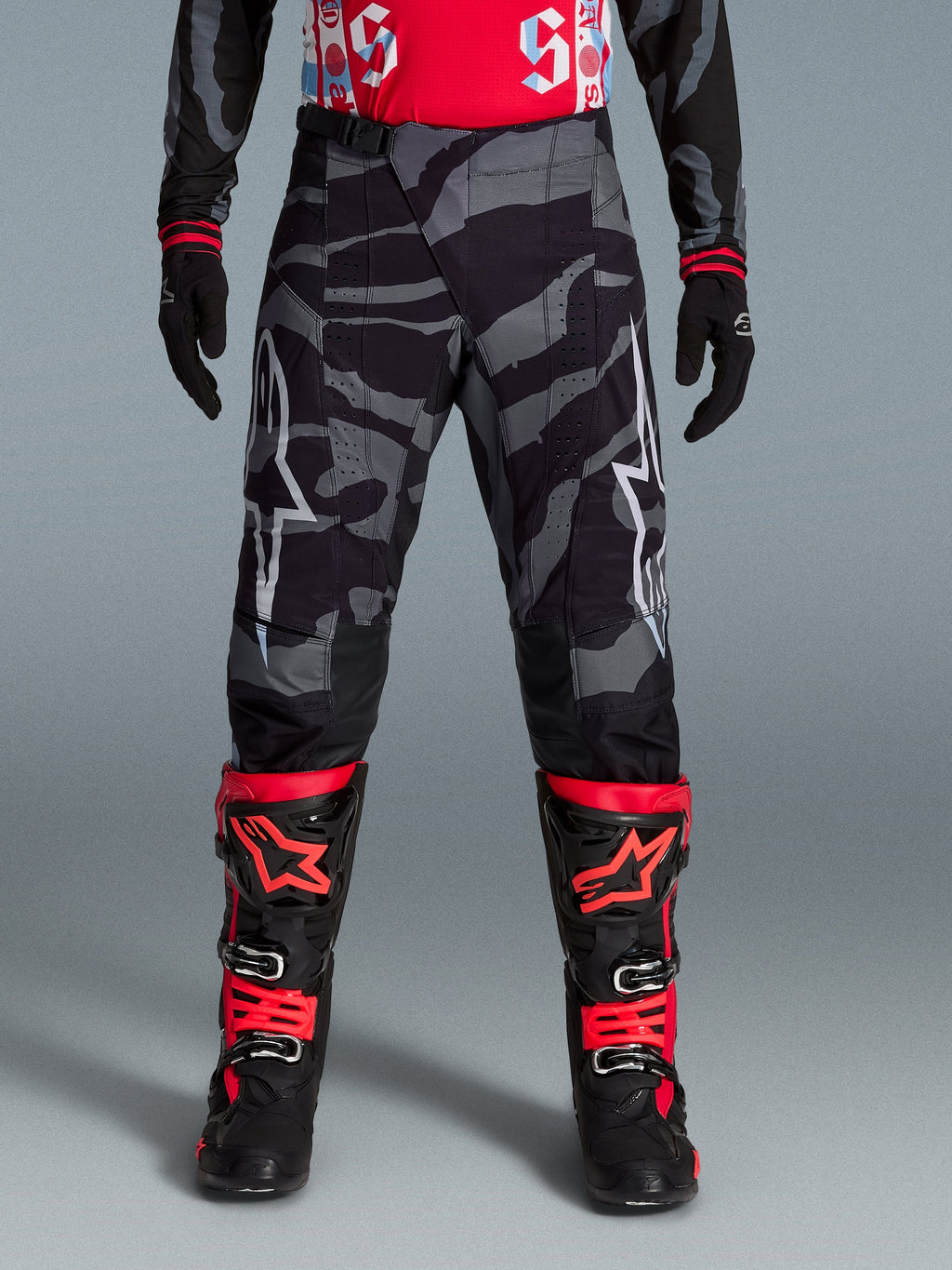 Alpinestars Limited Edition Techstar Beast Coast Pants, pirate black and orange motocross gear with a camo pattern.