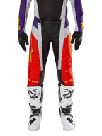 Alpinestars 2024 Techstar Ocuri Pants, Motocross Pants, Hot Orange Purple and Black, worn with matching jersey, black gloves, and white boots, featuring vibrant orange front panels, purple waist accents, and perforated grey sections, technical design for off-road racing