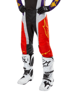Alpinestars 2024 Techstar Ocuri Pants, Motocross Racing Pants, Hot Orange, Black, and White with Yellow Star Graphic, worn with purple jersey and white boots, durable performance gear for off-road competition