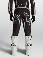 Alpinestars Youth Fluid Apex V2 Pants, black and silver motocross racing gear with ergonomic rear fit and star logos.
