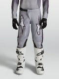 Alpinestars Youth Fluid Amber Pants, durable grey and black motocross pants for young riders in an off-road setting.