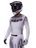 Alpinestars 2025 Supertech Maker Jersey, Motocross Racing Jersey, Silver and Black gradient, breathable stretch mesh with laser-cut perforations, worn with matching pants and helmet, featuring 'astars' branding, complete professional off-road gear