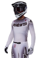 Alpinestars 2025 Supertech Maker Jersey, Motocross Racing Jersey, Silver and Black gradient, breathable stretch mesh with laser-cut perforations, worn with matching pants and helmet, featuring 'astars' branding, complete professional off-road gear