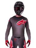 Alpinestars 2025 Supertech Lipan Jersey, Motocross Jersey, Smoke and Red, featuring a large red and white chest logo, worn with a black helmet and red and black gloves, athletic race fit with laser-cut perforations