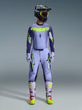 Motocross rider wearing complete Alpinestars 2026 Supertech Scenz racing gear, Purple and Yellow Fluo jersey with matching pants, black helmet with yellow goggles, light purple and neon boots, professional athletic-fit outfit for off-road racing