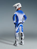 Alpinestars 2026 Supertech Scenz Gear Set, back view of a rider wearing the Ucla Blue White jersey and pants, white motocross helmet, and white racing boots, pro-level racing performance outfit