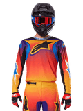 Alpinestars 2025 Fluid Wurx Jersey, Multicolor motocross jersey with orange and red gradient and purple accents, worn with matching gear, black helmet with blue and red goggles, and red gloves, featuring a large black star logo on the chest.