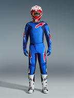 Motocross rider wearing the Alpinestars 2026 Fluid Grid Jersey in Blue and Red, matching blue pants with white and red star logos, red and white helmet with mirrored goggles, blue gloves, and white and black racing boots, complete off-road gear set.