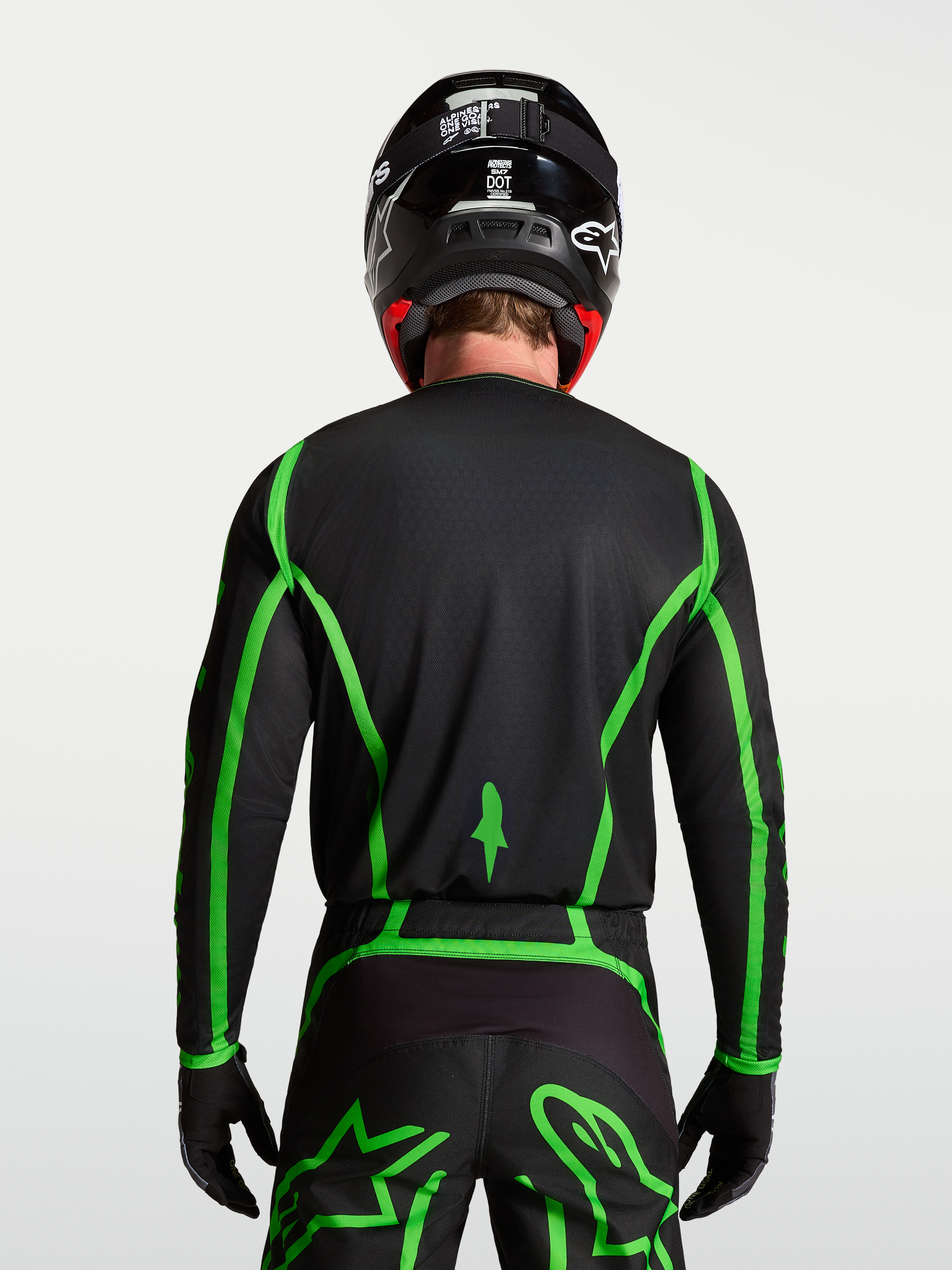 Alpinestars Fluid Apex V2 Jersey for motocross, black and fluorescent green, rear view on model showing extended back coverage.