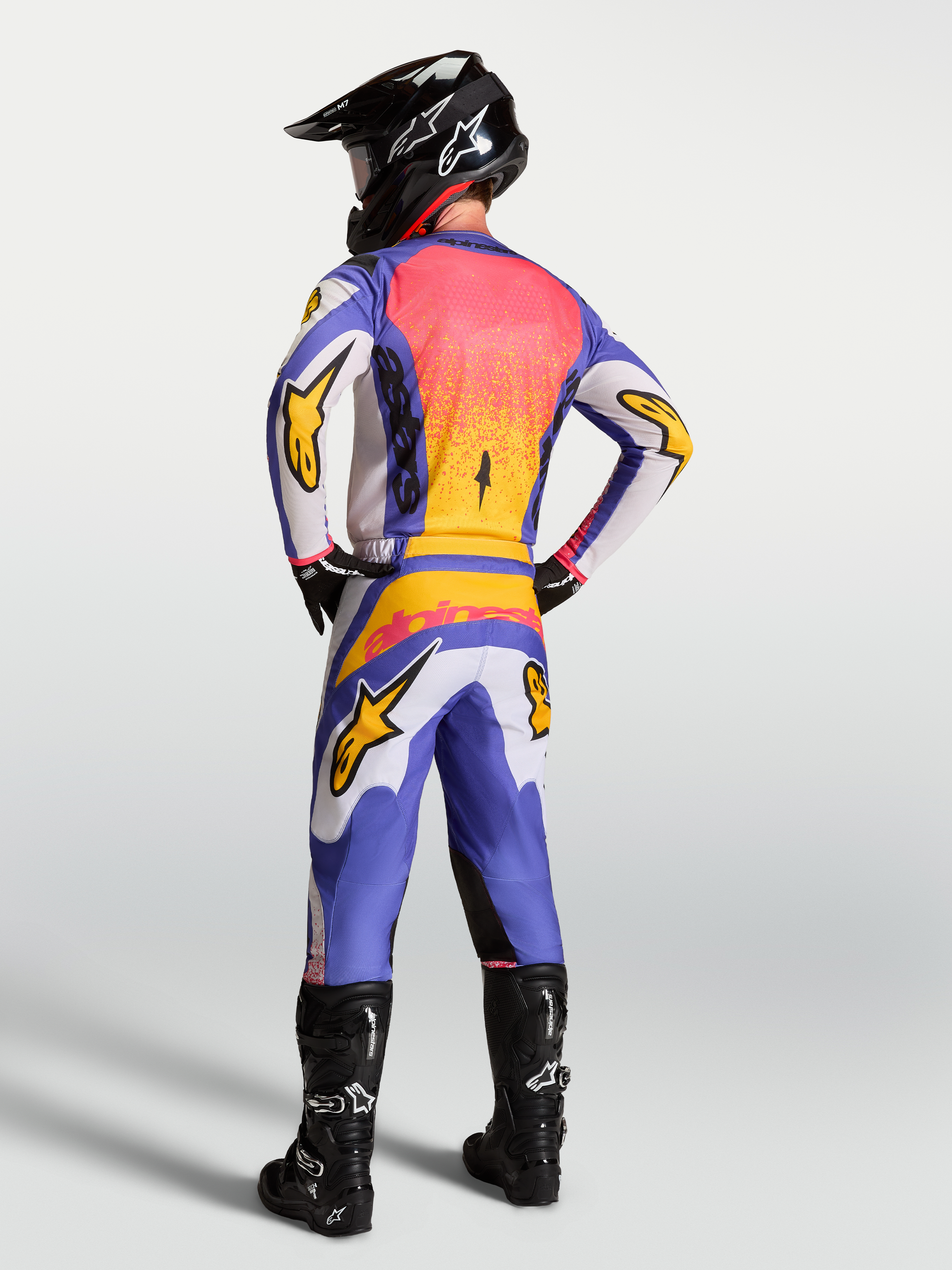 Alpinestars Fluid Drag Pants for men, blue and light lilac motocross gear with iris gold accents and a reinforced seat.
