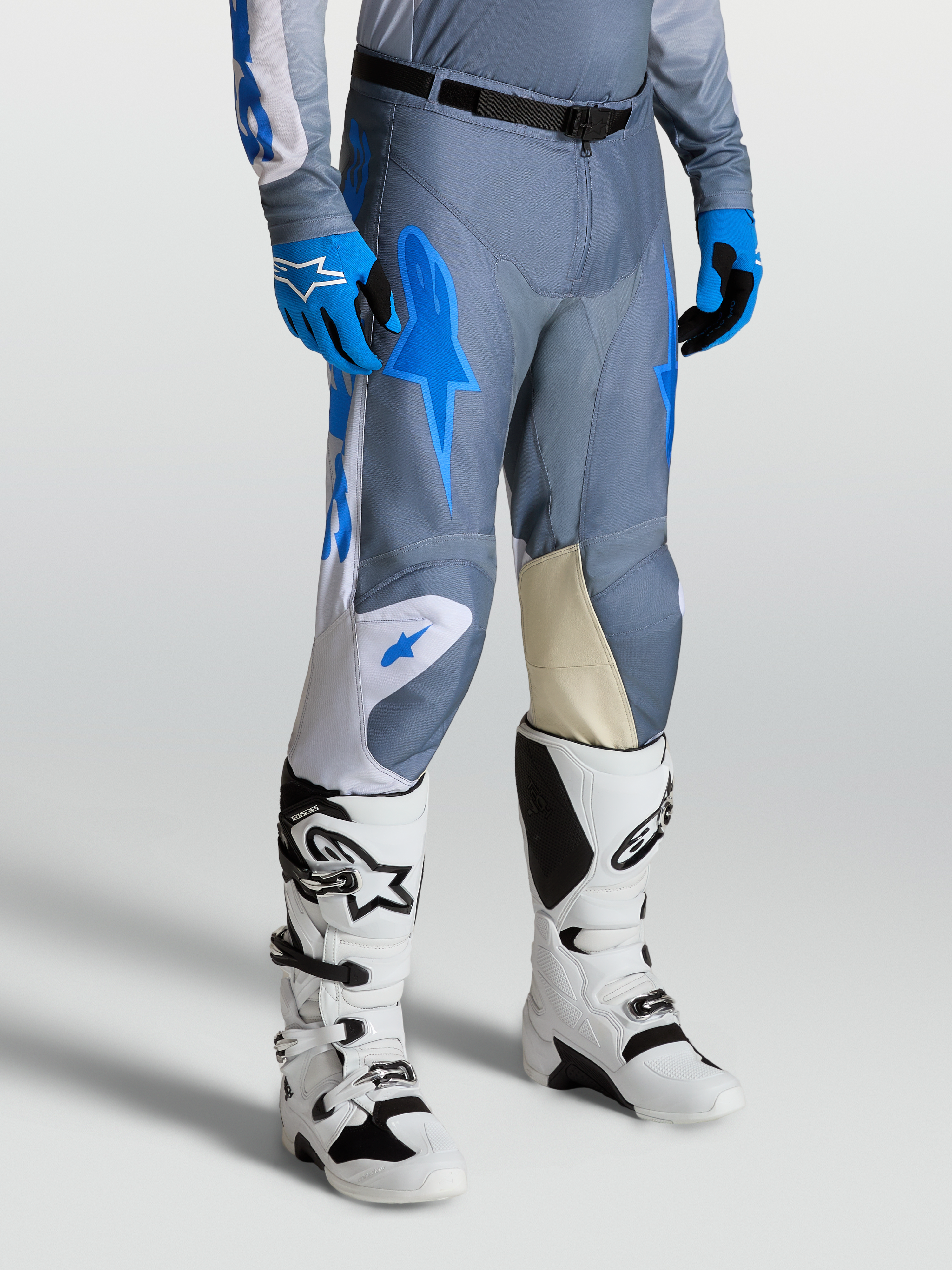 Alpinestars Racer Amber Pants, Men's Motocross Pants in Gray and UCLA Blue, with Goat Leather Knee Panels and White Techstar Boots.