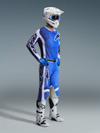 Motocross rider wearing the Alpinestars 2026 Racer Air Portl Jersey in Ucla Blue and White, paired with matching blue and white pants, white helmet, blue goggles, and white and black boots, full off-road racing kit