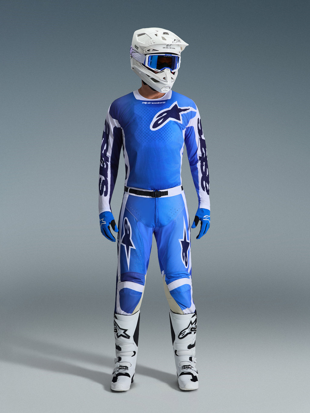 Motocross rider wearing Alpinestars 2026 Racer Air Portl Jersey in Ucla Blue White, paired with matching blue motocross pants, a white helmet with blue goggles, blue gloves, and white boots, complete professional gear set for off-road racing
