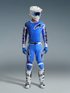 Motocross rider wearing Alpinestars 2026 Racer Air Portl Jersey in Ucla Blue White, paired with matching blue motocross pants, a white helmet with blue goggles, blue gloves, and white boots, complete professional gear set for off-road racing