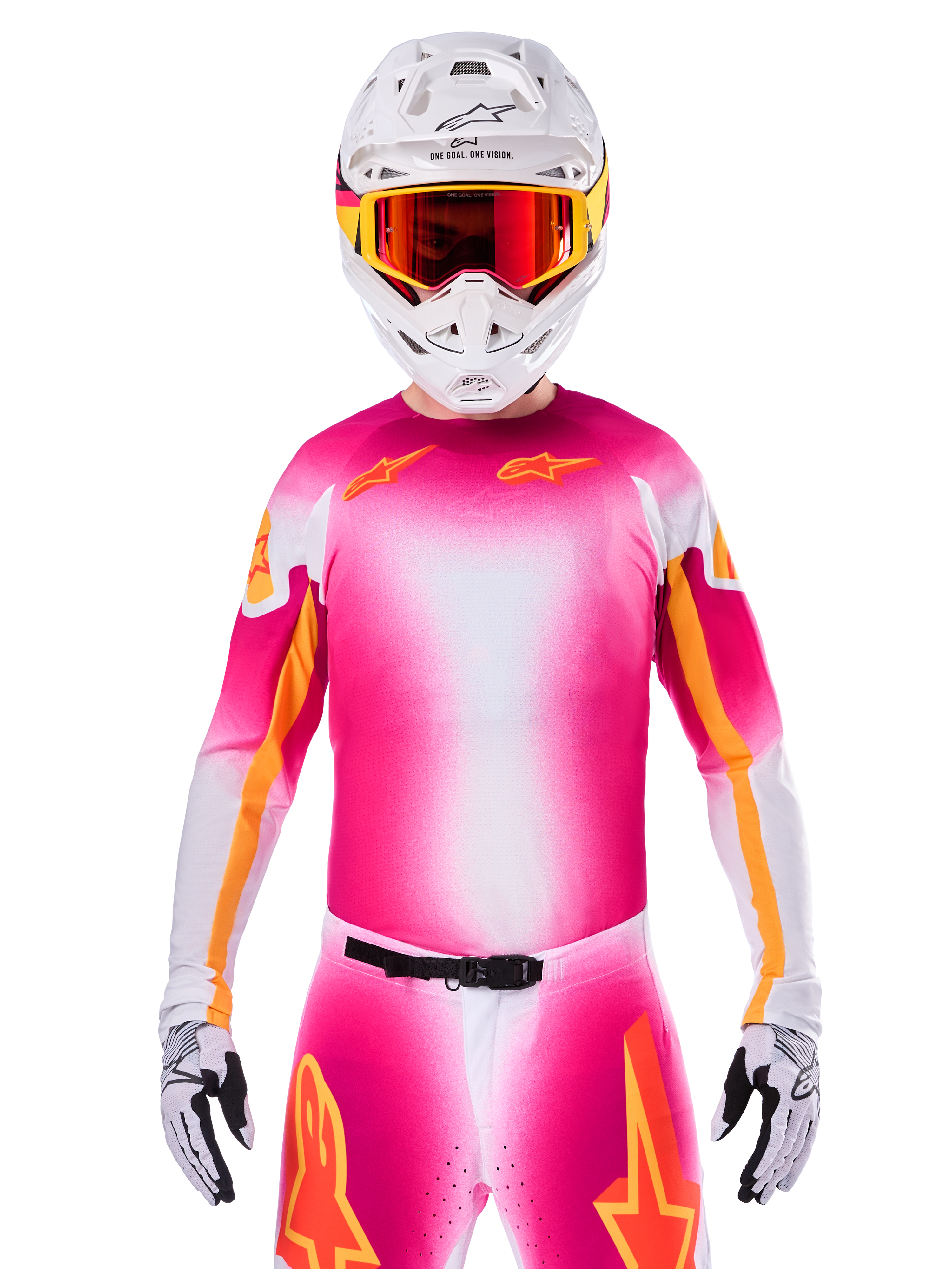 Motocross rider wearing the Alpinestars Limited Edition Supertech AFD MIG Jersey, Pink Fluo White gradient design with orange star logos, matching pants, white helmet, and red-tinted goggles, elite off-road racing apparel.
