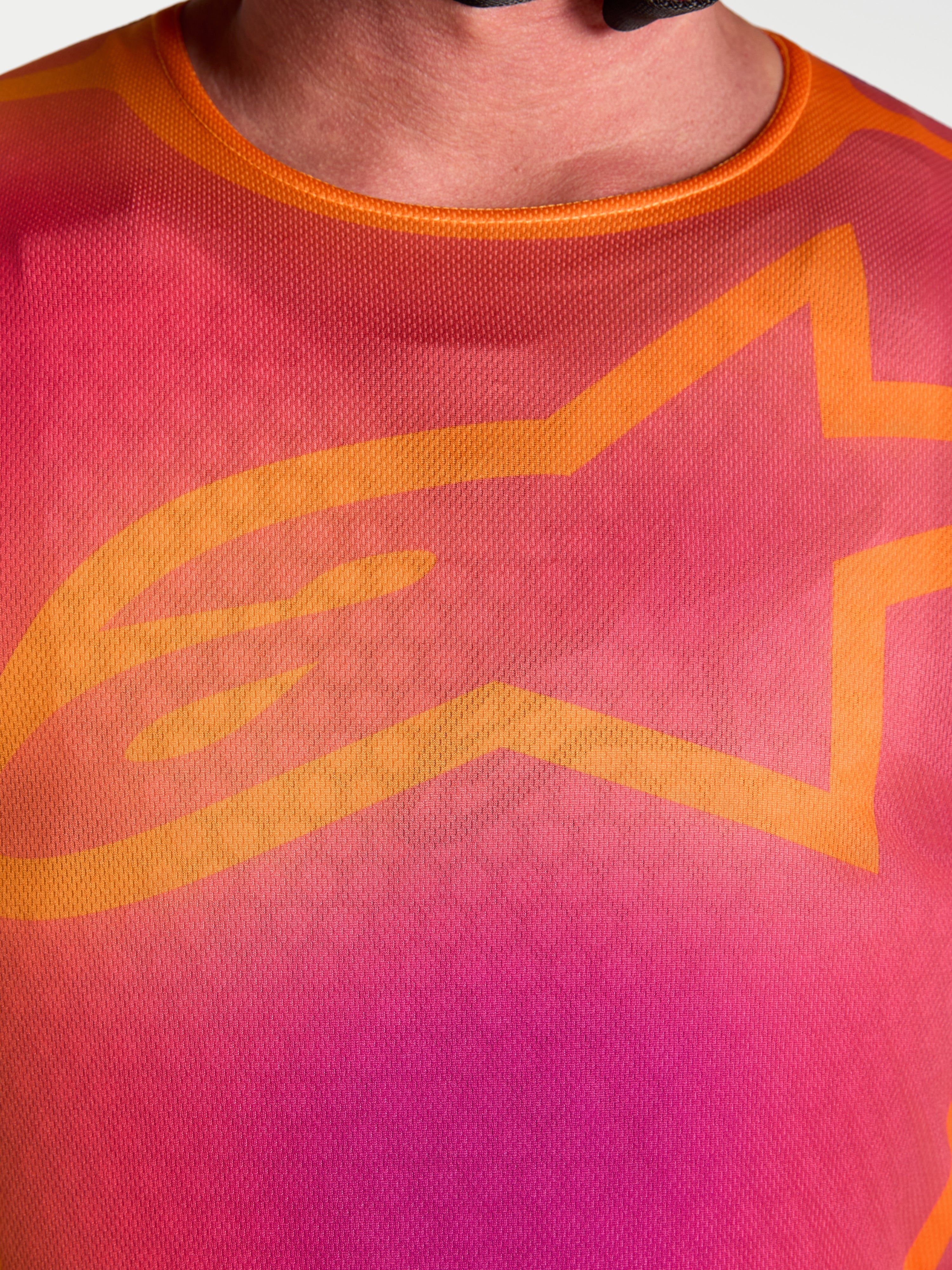 Alpinestars Fluid Kepler Motocross Jersey, close-up of purple and orange chest design with iconic orange A-star logo.