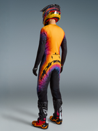 Alpinestars Supertech Black Hole Motocross Gear Set, black and orange with purple cosmic graphics, male rider back view.