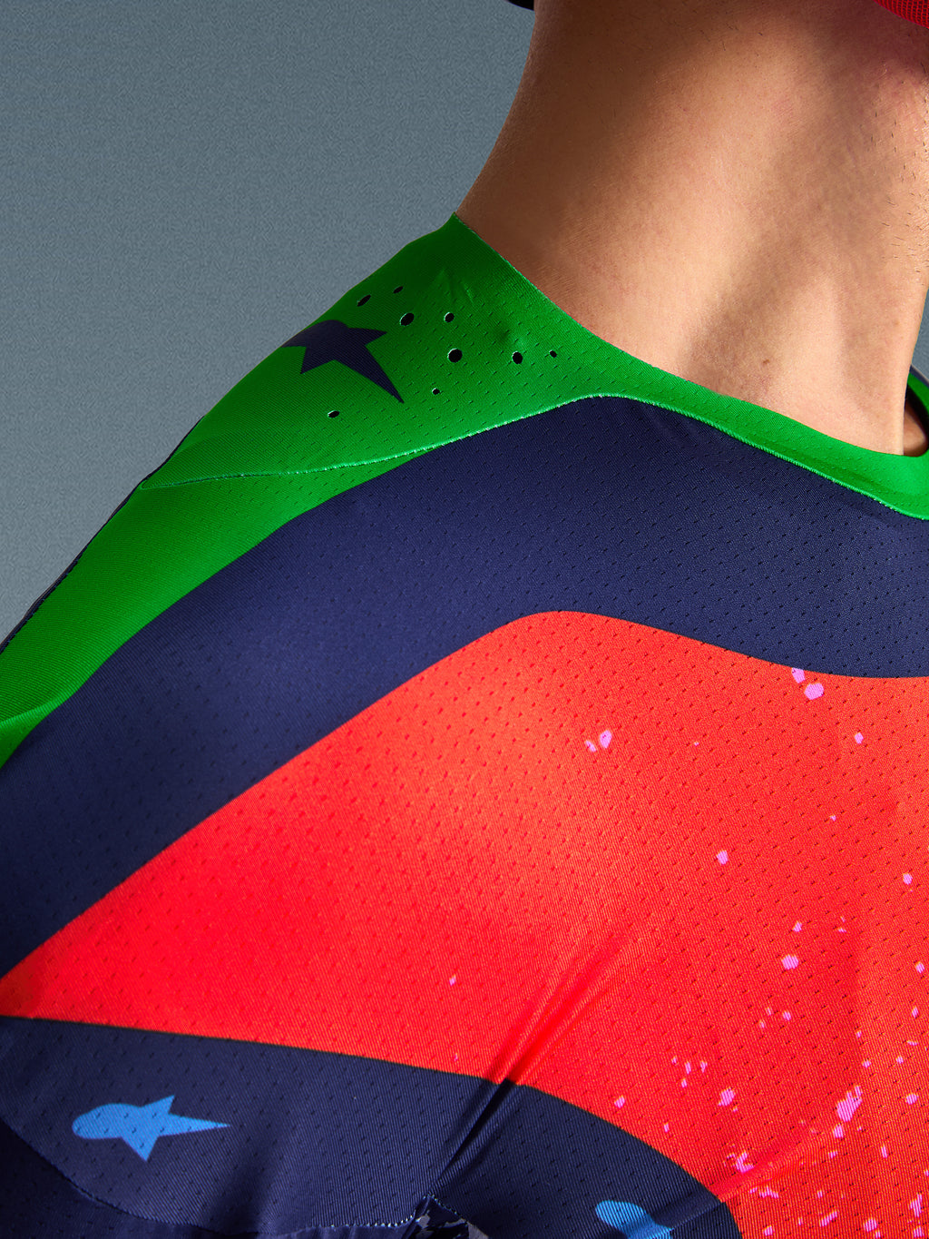 Close-up of the Alpinestars Limited Edition Supertech Records Jersey, multicolor design with green shoulder, navy and red panels, featuring laser-cut perforations and breathable mesh fabric for professional motocross performance.