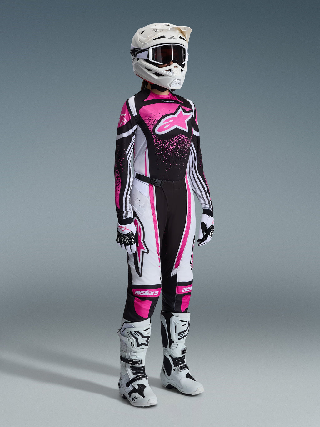 Alpinestars 2026 Stella Techstar Nomur Gear Set, full women's motocross racing gear, vibrant pink black and white jersey with matching pants, white helmet and goggles, white and black boots, professional coordinated motocross outfit