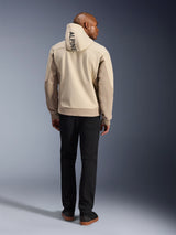 Alpinestars Radium Tech Hoodie, Mastic Aluminum, back view showing vertical 'ALPINE' text on the hood, technical 3L windproof shell urban motorcycle jacket with tan panels, worn with black pants