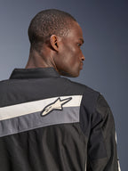 Alpinestars T-Dyno WR Jacket, Textile Motorcycle Jacket, Black Dark Gray and Ecru, close-up of the upper back and shoulder with horizontal stripes and Alpinestars star logo, worn by a model, heritage-inspired design for road riding