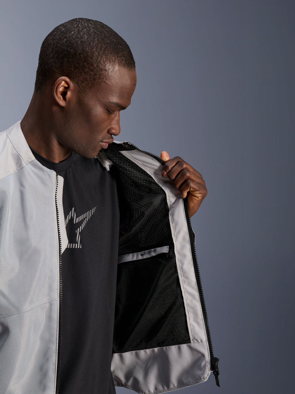 Male model wearing the Alpinestars C-1 Air Jacket in Silver, opening the front to reveal the black tech mesh interior lining and a zippered waterproof inner pocket.