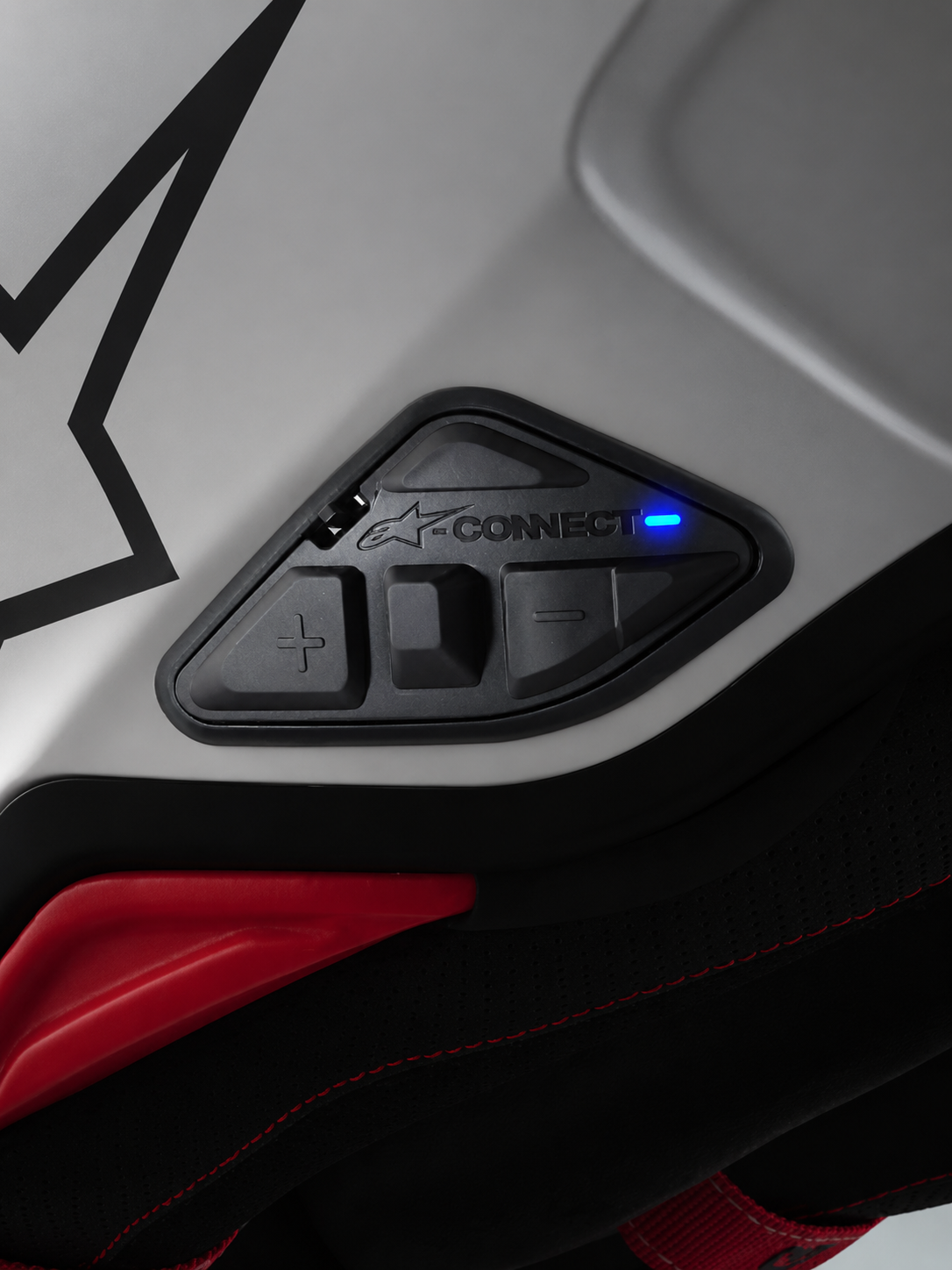 Alpinestars A-Connect Communication System, motorcycle helmet intercom control unit with 4-key layout and active blue status LED, installed on helmet shell