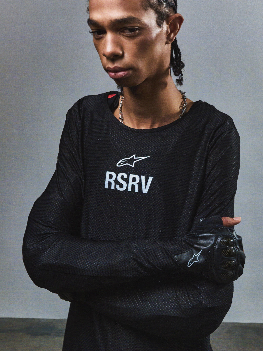 Alpinestars RSRV Knuckle LS Tee, Black long-sleeve shirt with white RSRV logo, textured mesh pattern, premium streetwear collection, worn with black gloves