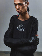 Alpinestars RSRV Knuckle LS Tee, Black long-sleeve shirt with white RSRV logo, textured mesh pattern, premium streetwear collection, worn with black gloves