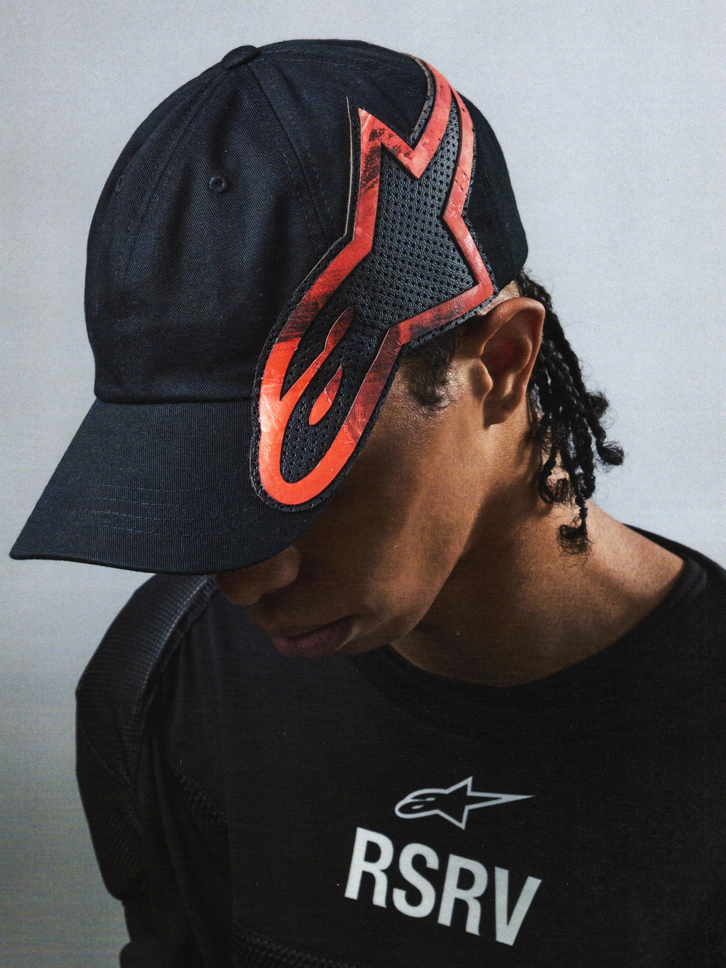 Alpinestars RSRV Lowside Hat, Black Cap with Red and Black Flame Logo, Unisex Lifestyle Streetwear, Perforated Construction, Worn with RSRV Black Shirt