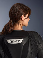 Alpinestars Stella GP-R7 2-Piece Leather Suit, Black, close-up view of the back featuring the GP-R7 logo on the aerodynamic hump, leather accordion stretch panels on shoulders, premium race-grade construction for women.