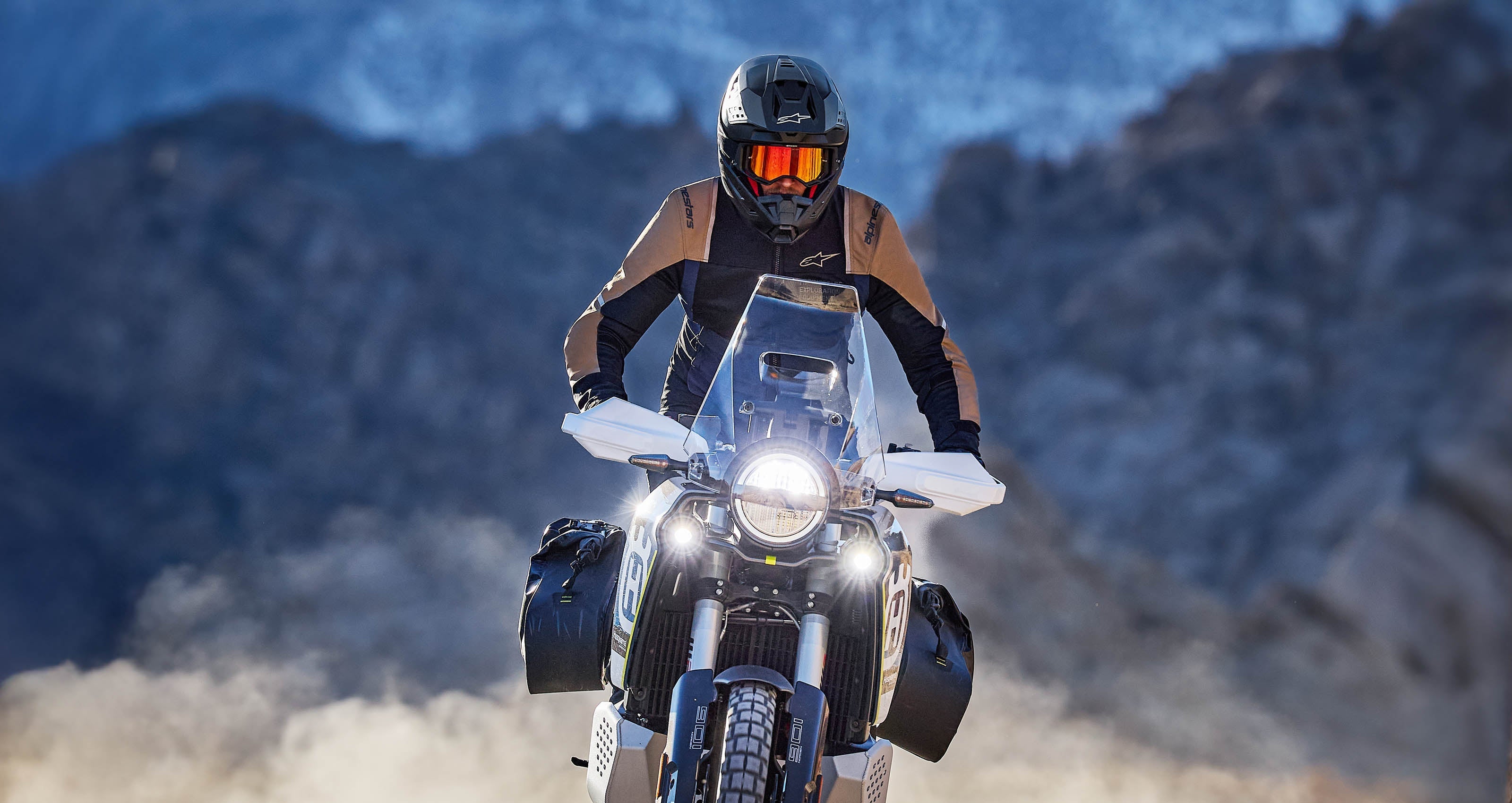 Alpinestars ST-2 Air Jacket, Black and Tan textile adventure motorcycle gear for men, worn on a dusty mountain trail.