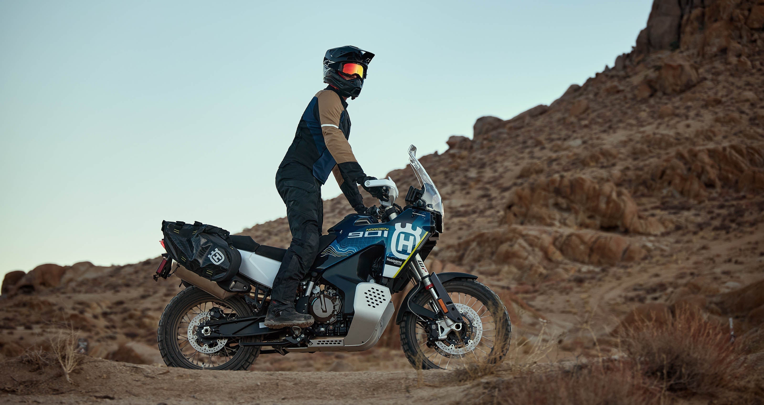 Alpinestars ST-2 Air Jacket, adventure motorcycle touring jacket for men, Gray and Red, worn on a rocky desert trail.