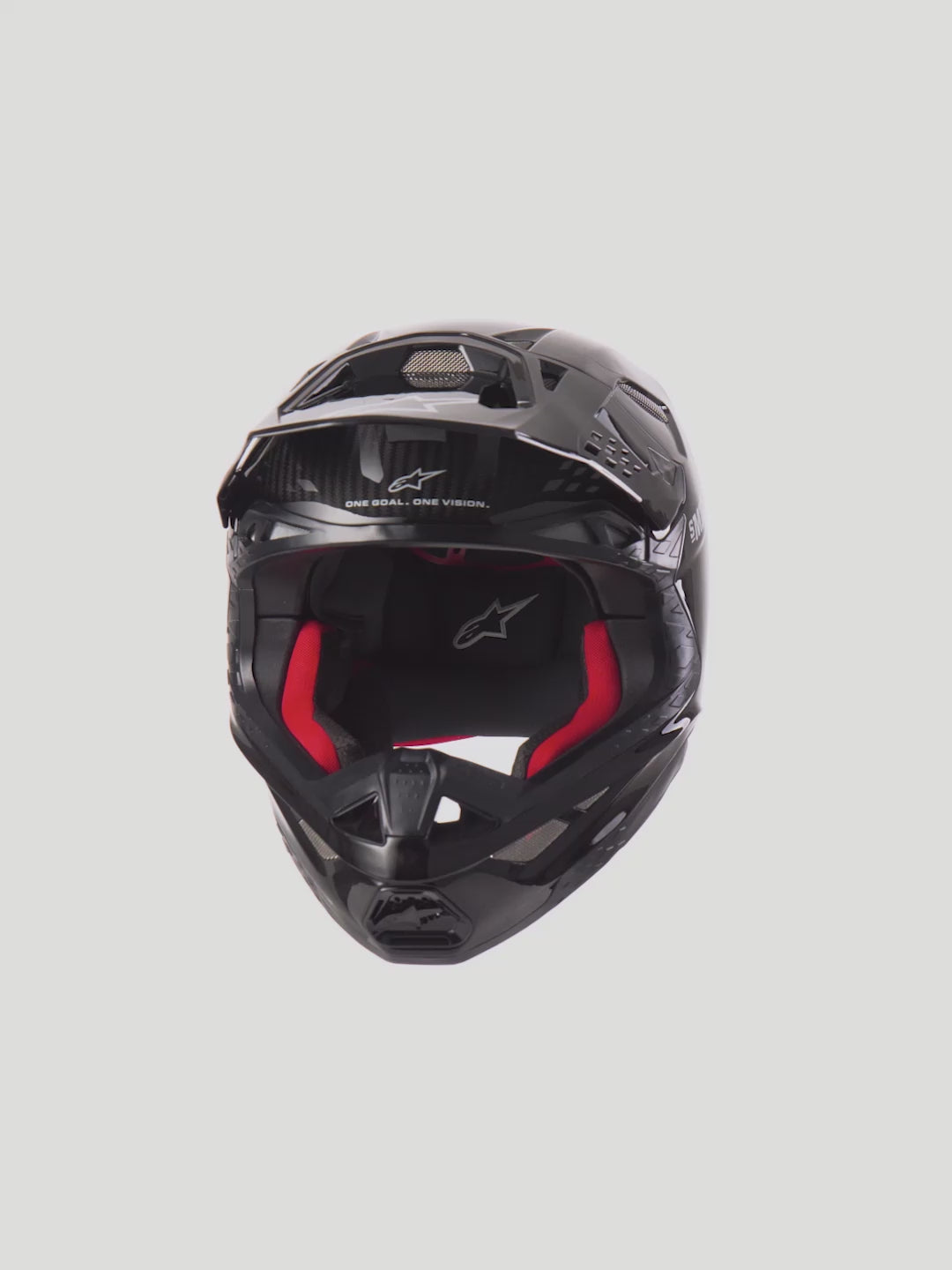 Alpinestars Supertech M10 Solid Helmet  Black Glossy Carbon Motocross Helmet with red interior padding. High-performance off-road racing protection featuring a 3K carbon shell, MIPS technology, and 28-port ventilation system for maximum airflow.